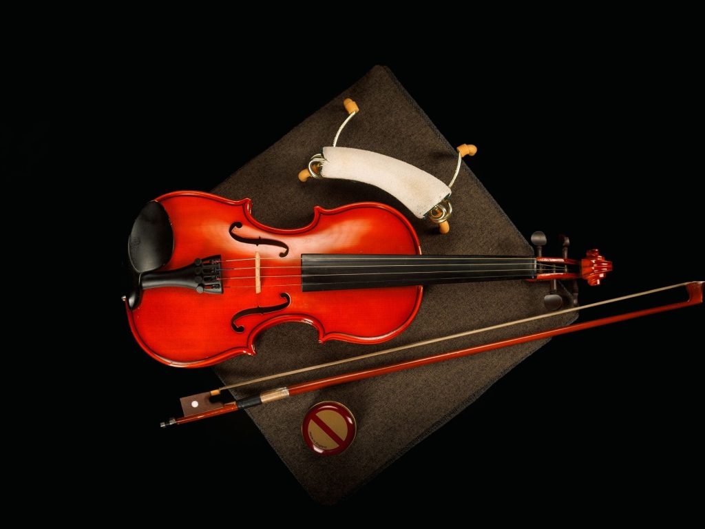 Красная скрипка со смычком на черном фоне