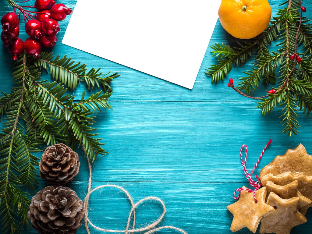 Еловые ветки с печеньем, шишками и декором на синем фоне