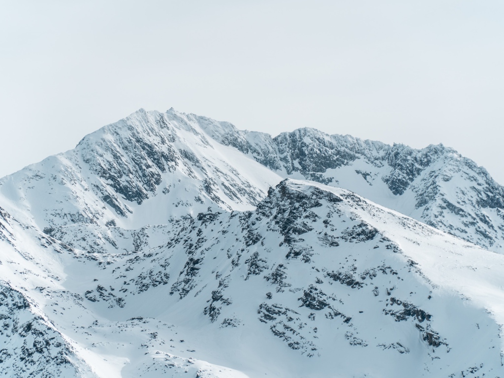 Заснеженная гора под серым небом 