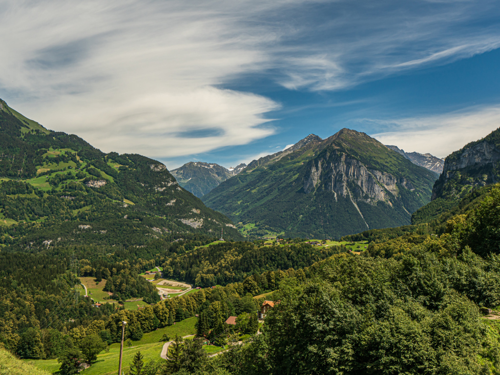 Высокие покрытые зеленью альпы под красивым небом, Швейцария 