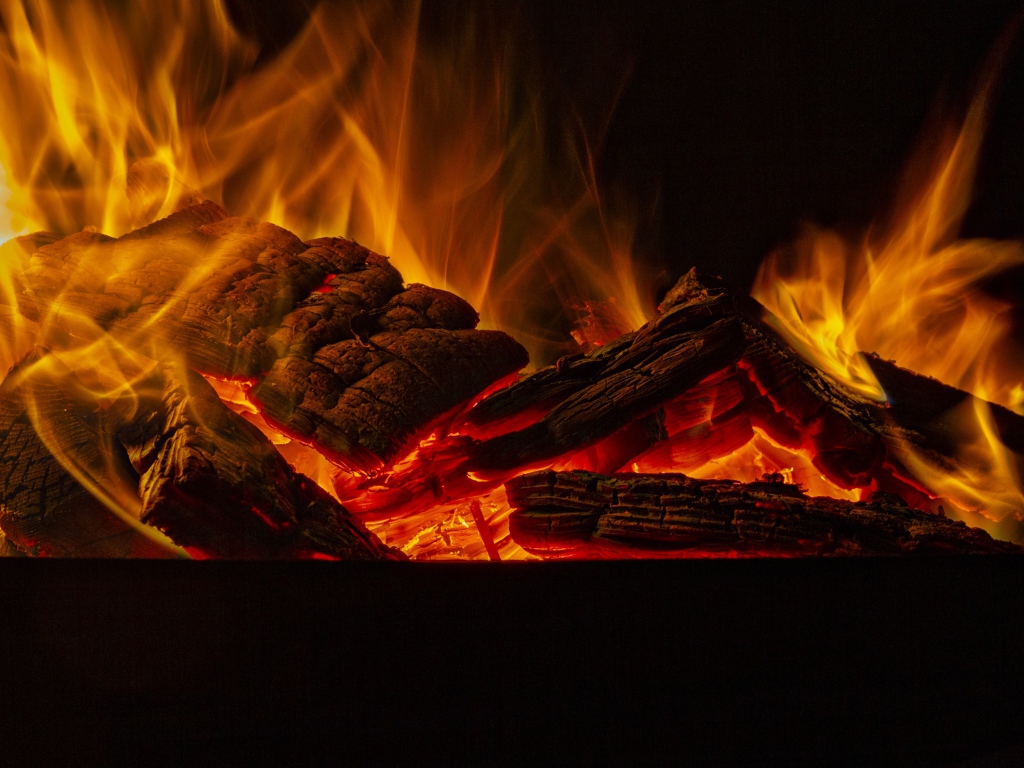 Дрова горят желтым пламенем в камине