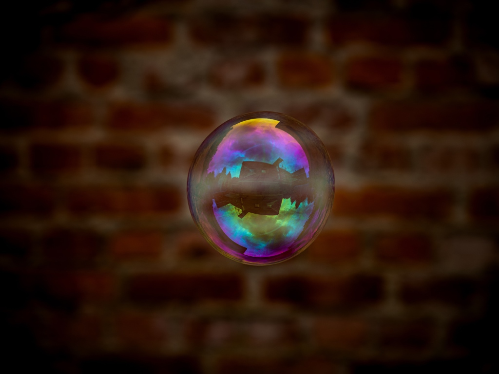 Мыльный пузырь в воздухе на фоне стены