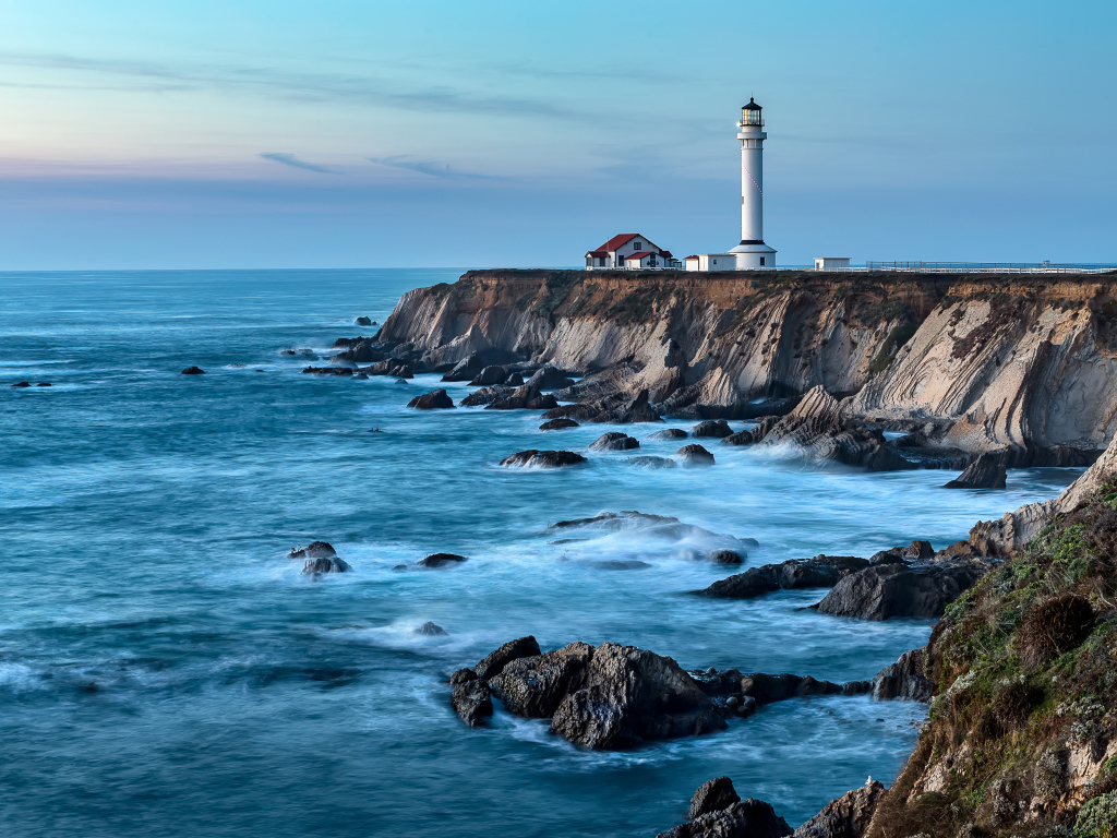 Маяк на берегу моря на краю утеса 