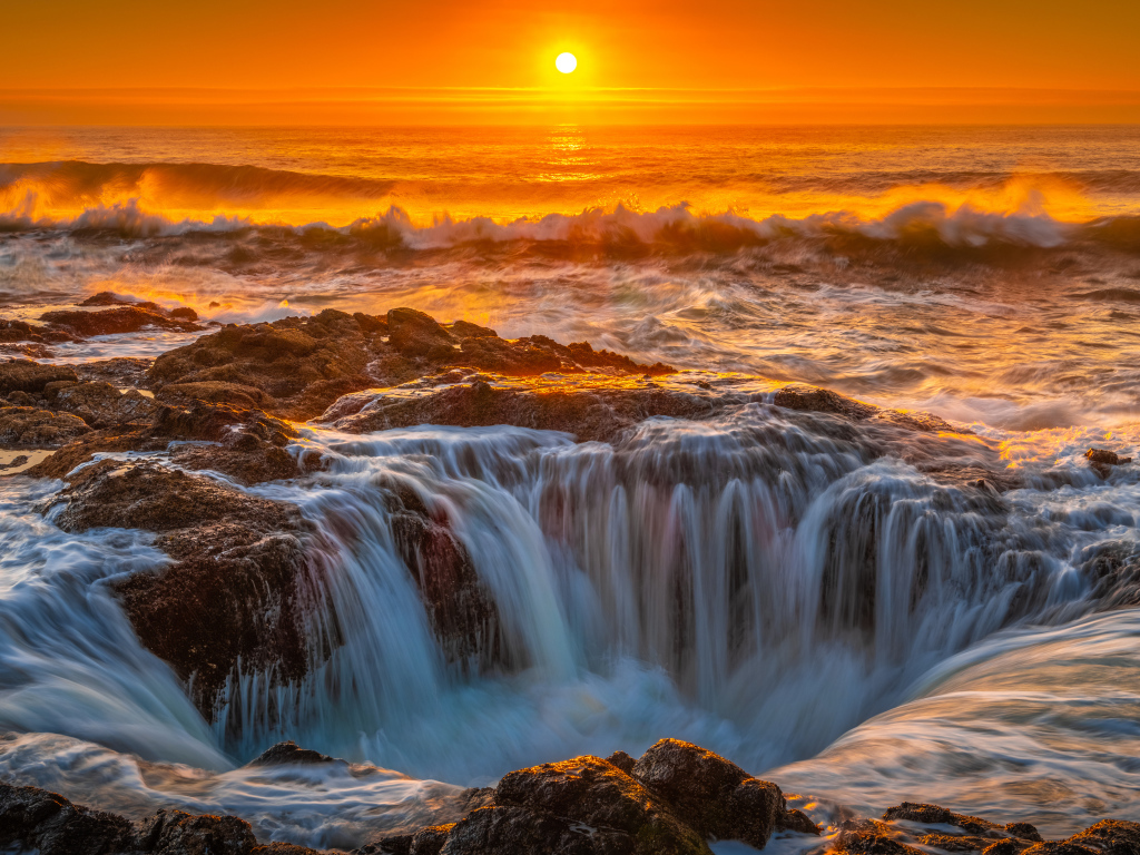 Вода океана стекает в дыру на закате солнца
