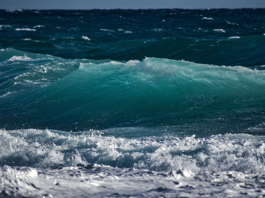 Волны с белой пеной поднимаются в море