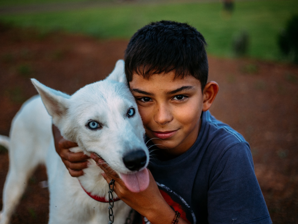 Мальчик с белой собакой с голубыми глазами 