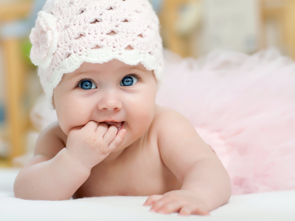 Милая голубоглазая малышка в розовой шапке 
