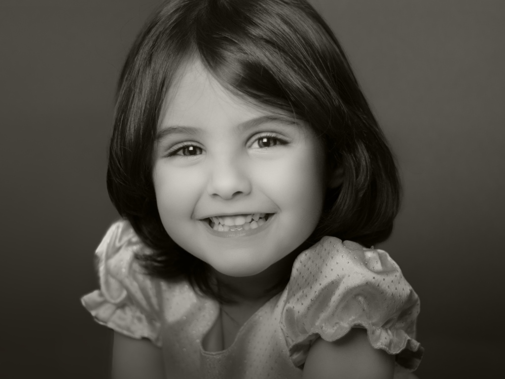 Милая улыбающаяся маленькая девочка черно-белое фото