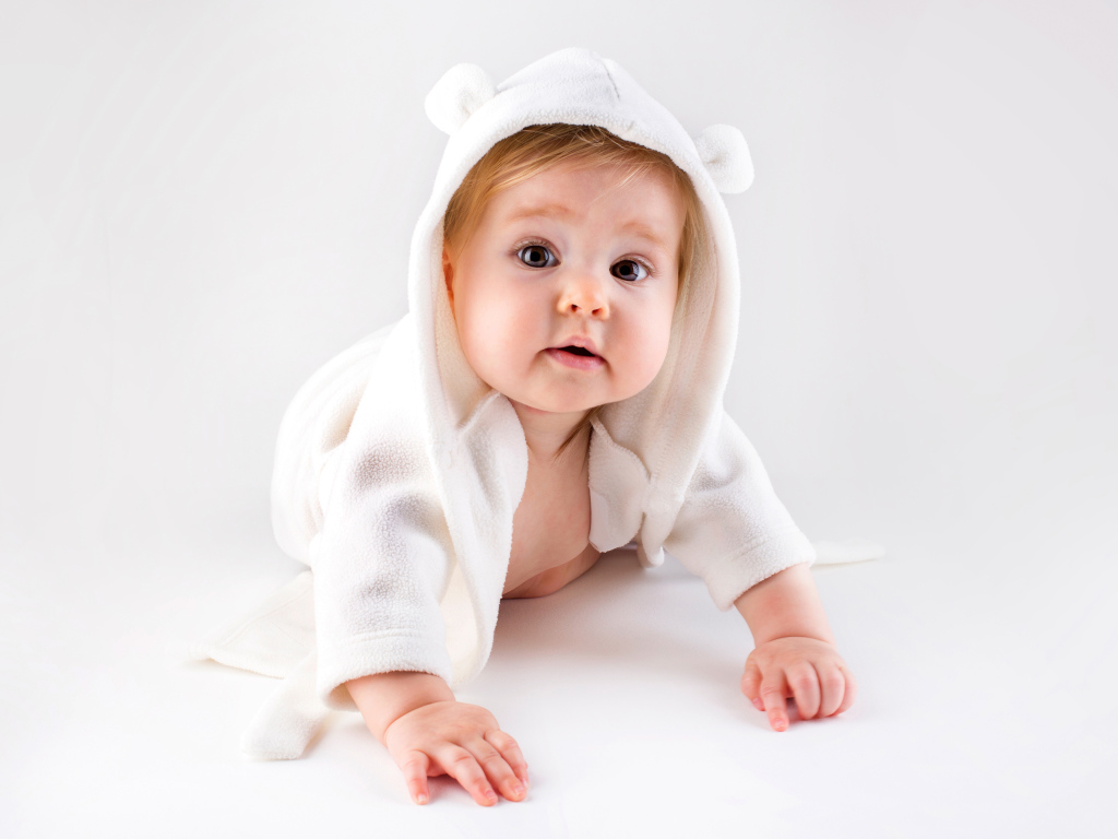 Забавный малыш ползает в белом наряде 