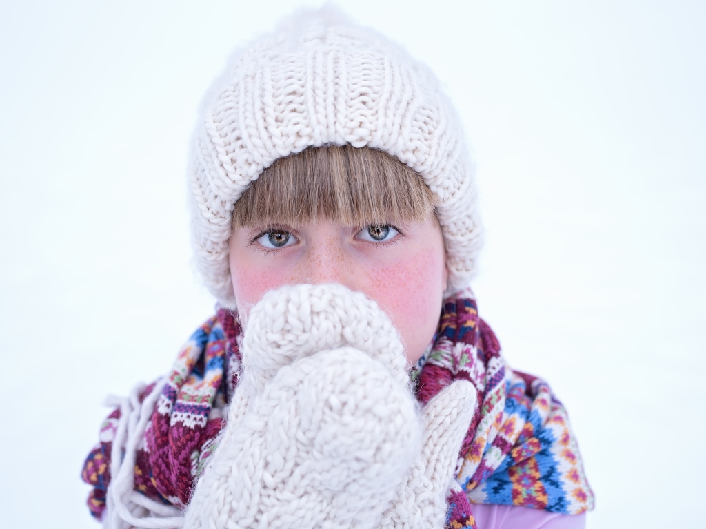 Девочка в рукавицах и белой шапке
