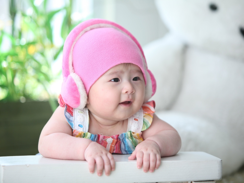 Маленький ребенок азиат в розовой шапке 