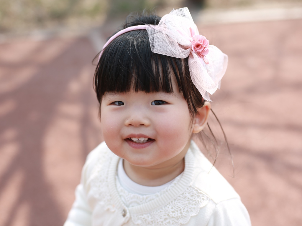 Маленькая девочка азиатка с бантом на голове 