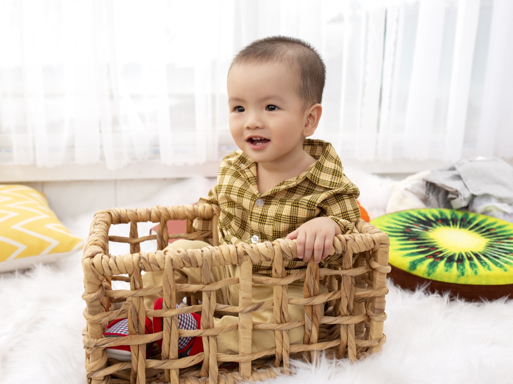 Маленький мальчик сидит в ящике в игровой комнате