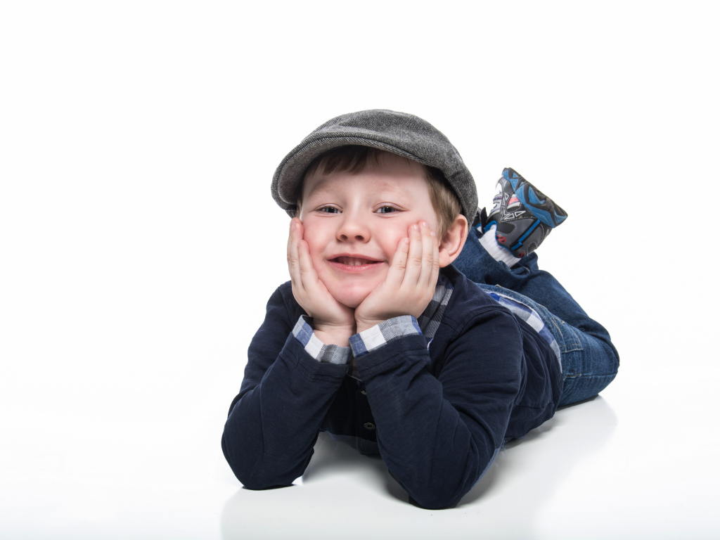 Маленький милый мальчик в кепке на белом фоне