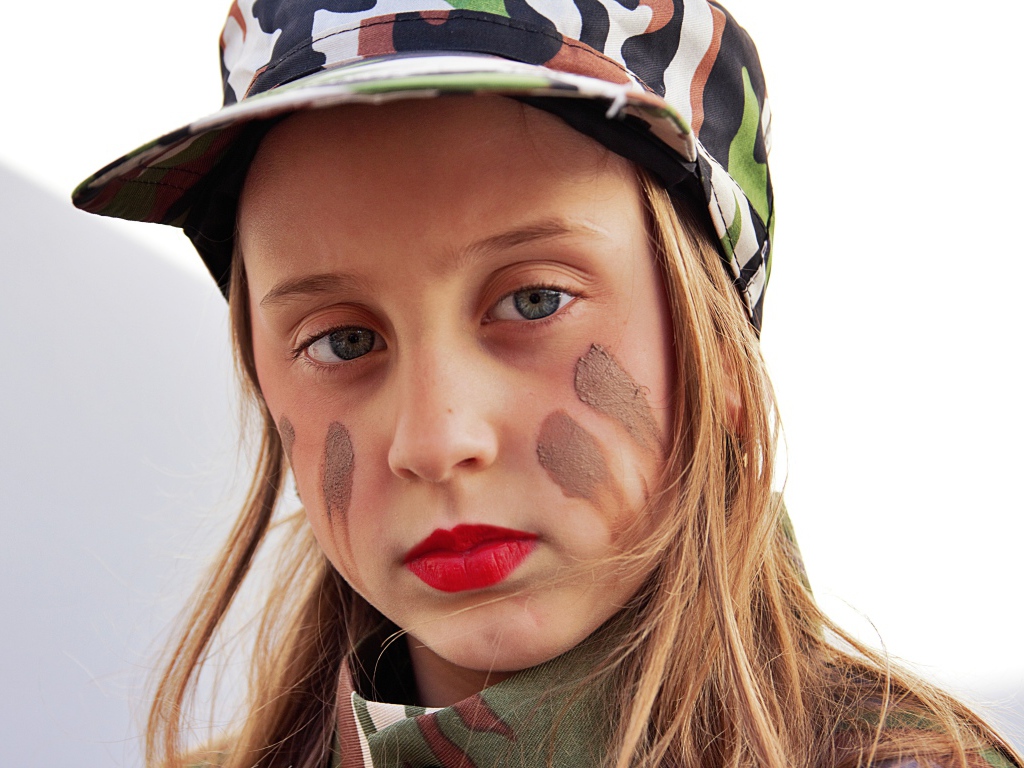 Маленькая девочка в кепке с грязью на лице