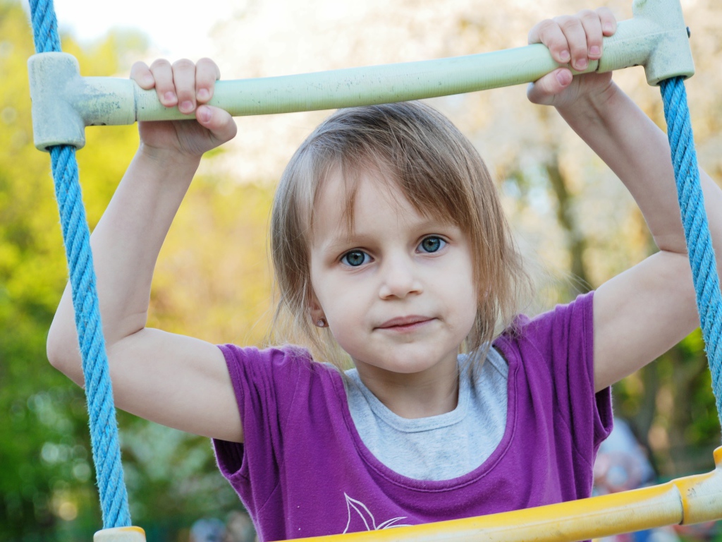 Маленькая девочка на подвесной лестнице 