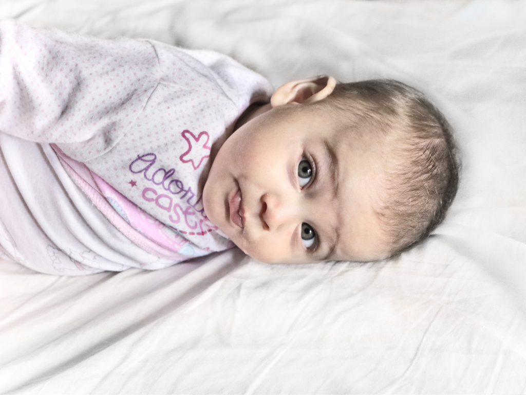 Маленький новорожденный ребенок лежит на кровати 