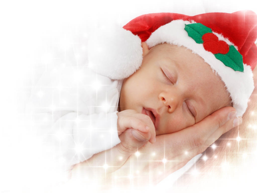 Маленький спящий ребенок в новогодней шапке 