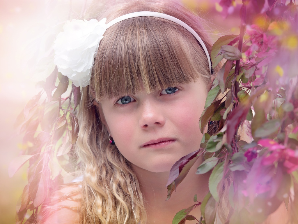 Грустная маленькая девочка у ветки дерева 