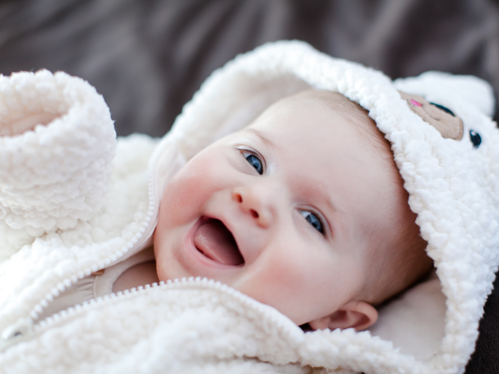 Улыбающийся милый ребенок в теплом костюме 