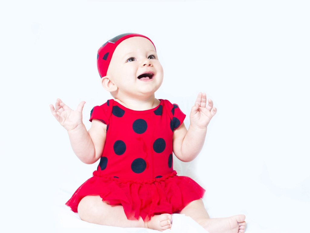 Улыбающаяся девочка в красном платье с черными кругами