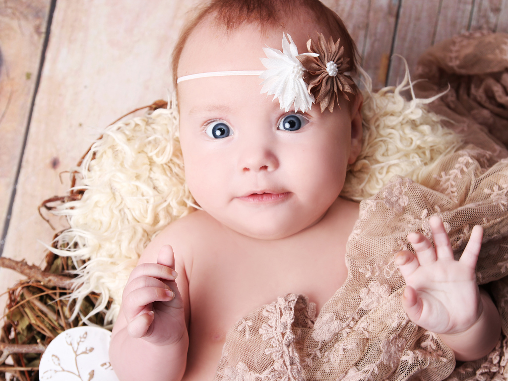 Удивленная голубоглазая новорожденная девочка 