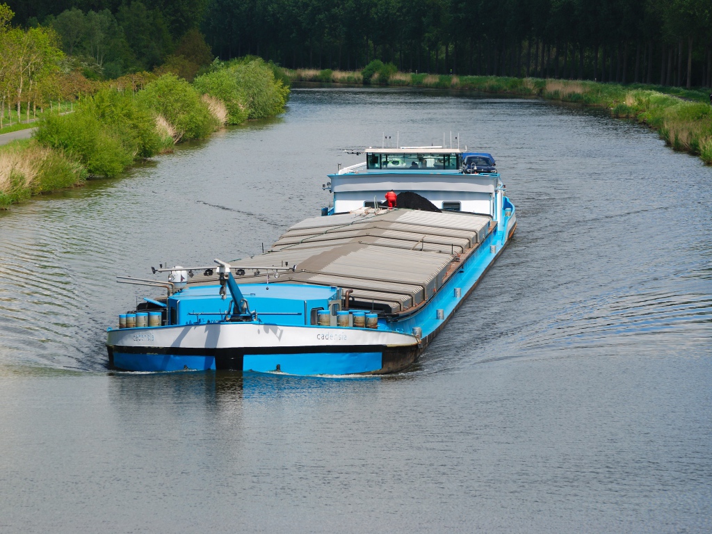 Грузовая баржа плывет по реке 