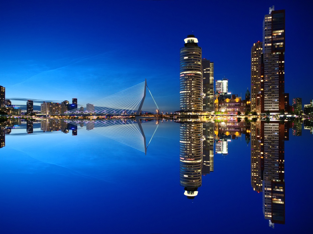 Skyscrapers and bridge are reflected in calm water