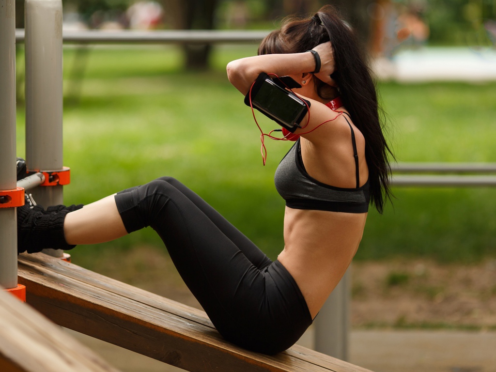 Девушка качает пресс на тренажере 