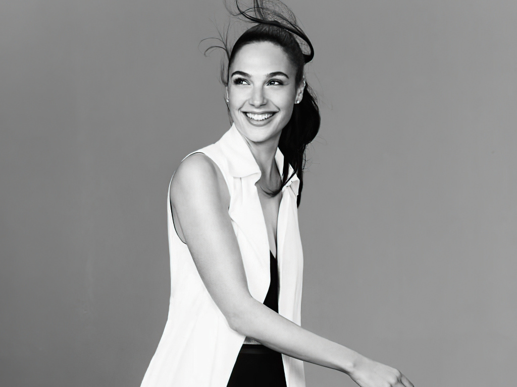 Улыбающаяся актриса Галь Гадот на сером фоне