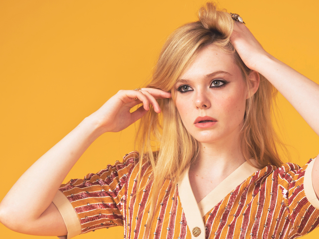 Молодая американская актриса Эль Фэннинг на желтом фоне