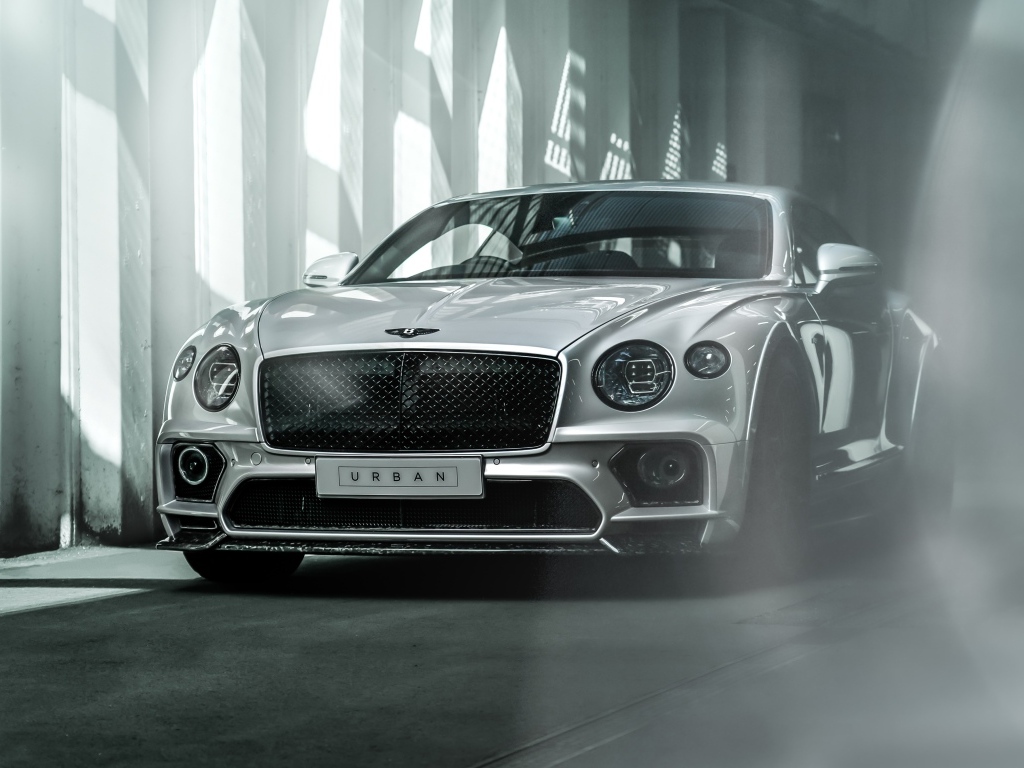 Серебристый автомобиль Bentley Continental GT в здании