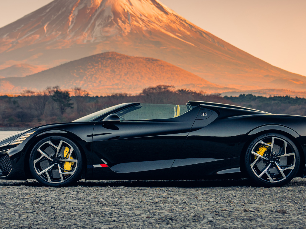 Черный автомобиль Bugatti W16 Mistral  на фоне горы