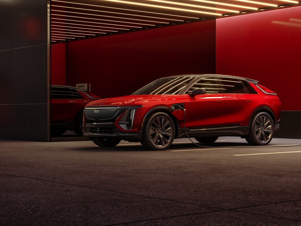 Красный электрокар Cadillac Lyriq Sport 2024 года на заправке