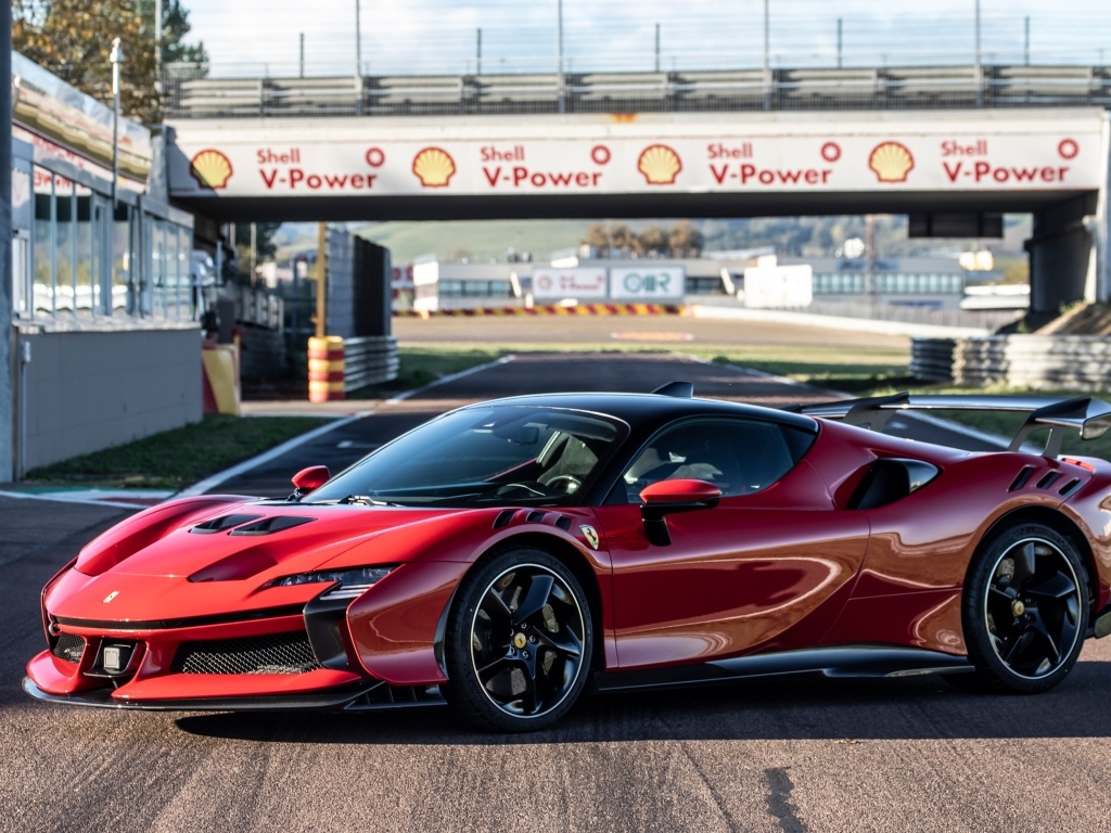 Красный автомобиль Ferrari SF90 XX Stradale на стадионе