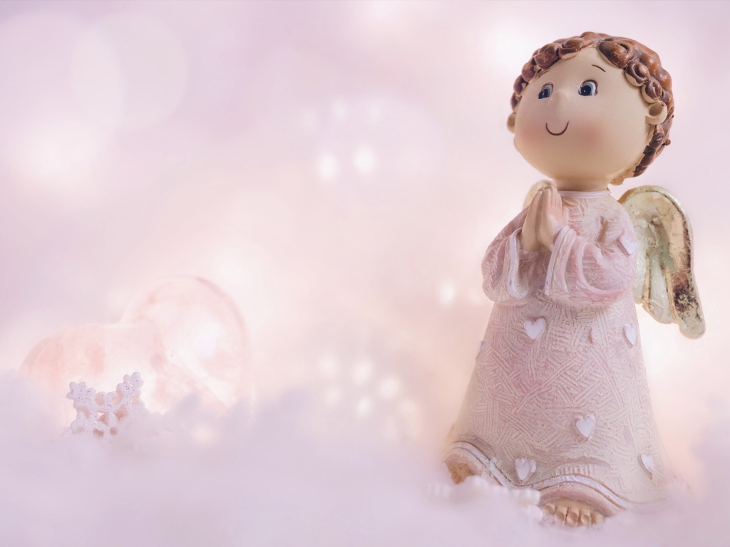 Статуэтка ангела на розовом фоне