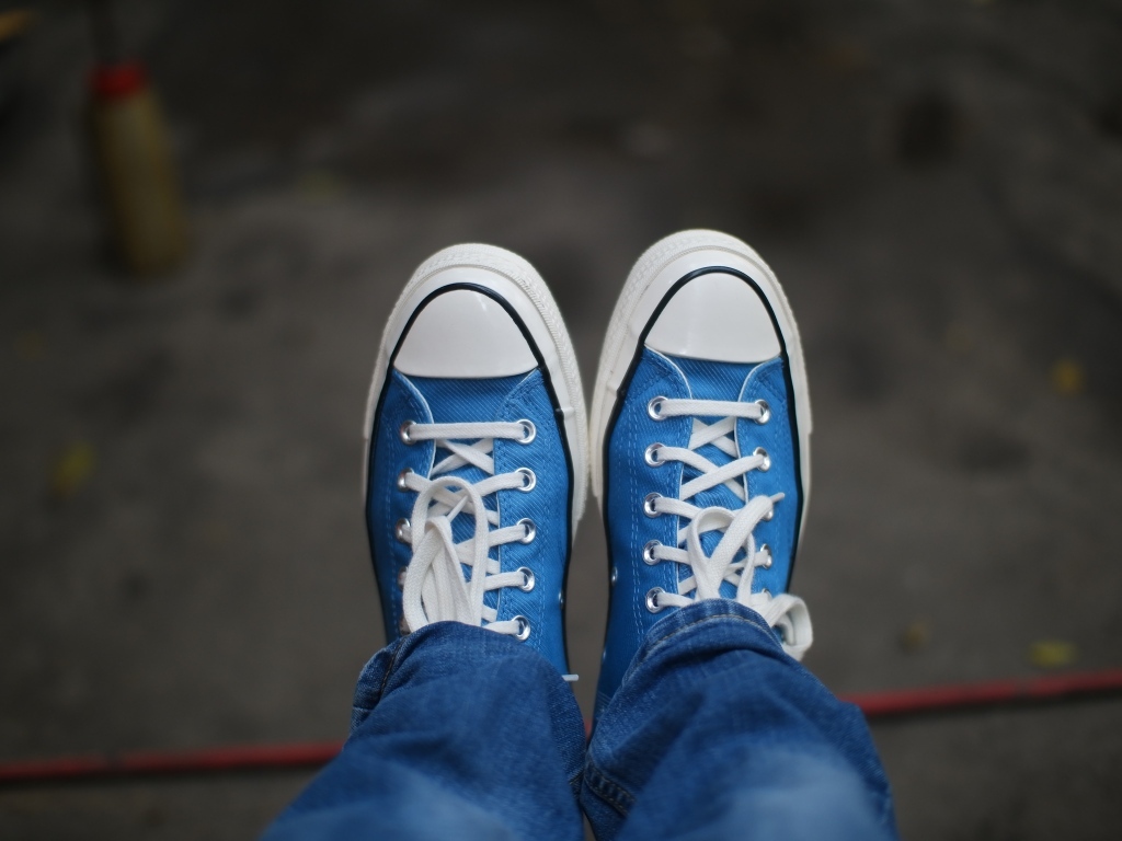 Кеды на ногах в джинсах