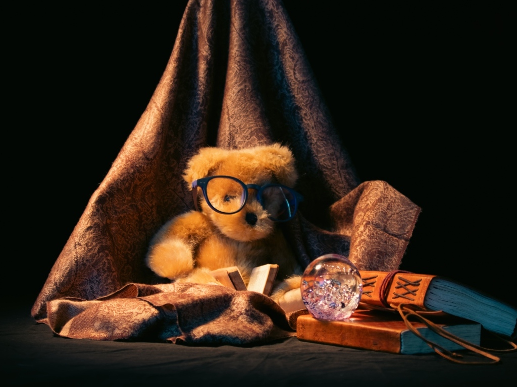 Игрушечный медвежонок с книгами на черном фоне