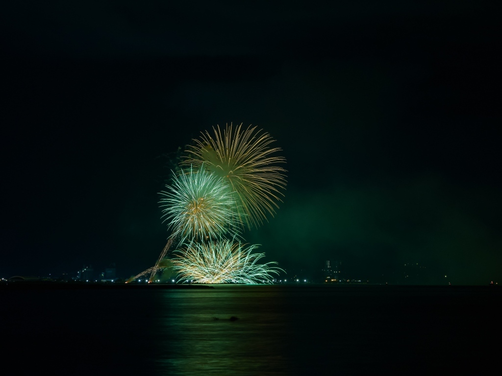 Вид с воды на красивые искры салюта