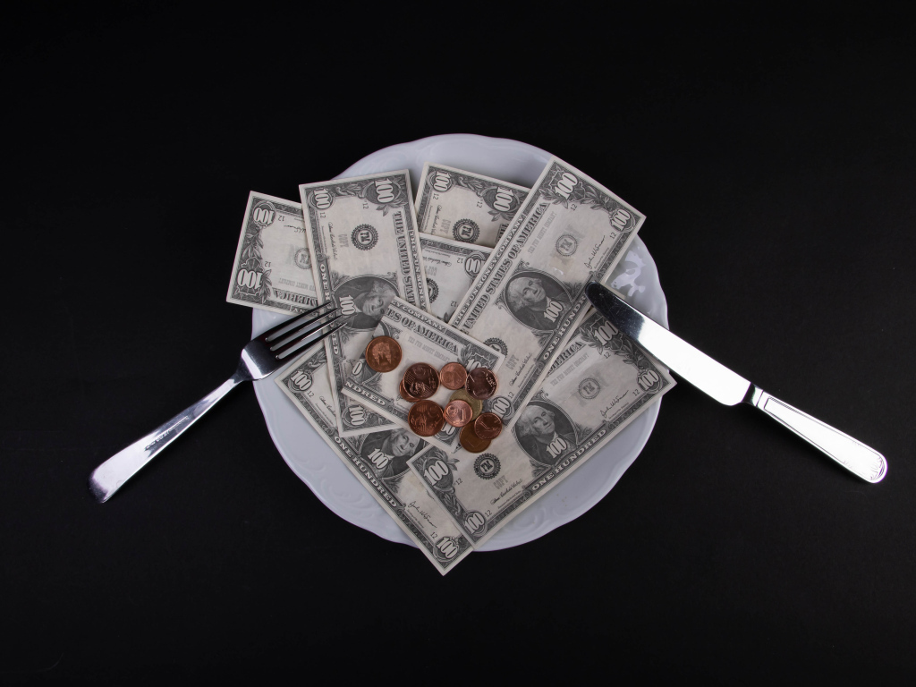 Тарелка с долларами на черном фоне