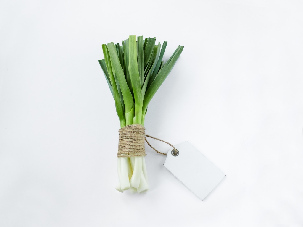 Пучок зеленого лука на белом фоне
