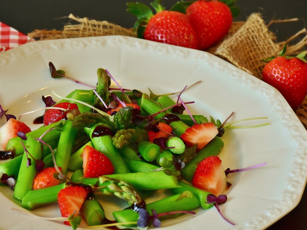 Спаржа в тарелке с клубникой