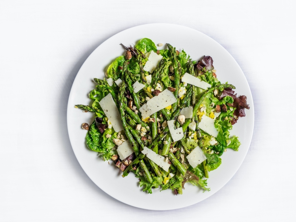 Спаржа на белой тарелке с сыром