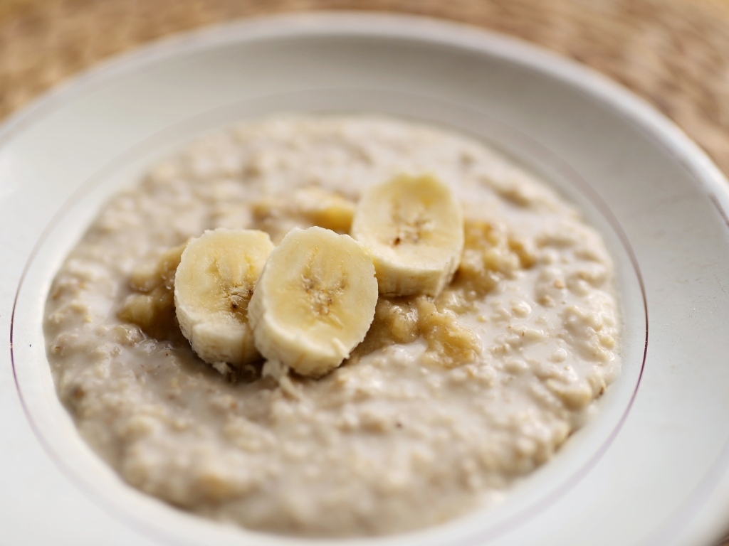 Овсяная каша с кусочками банана в тарелке