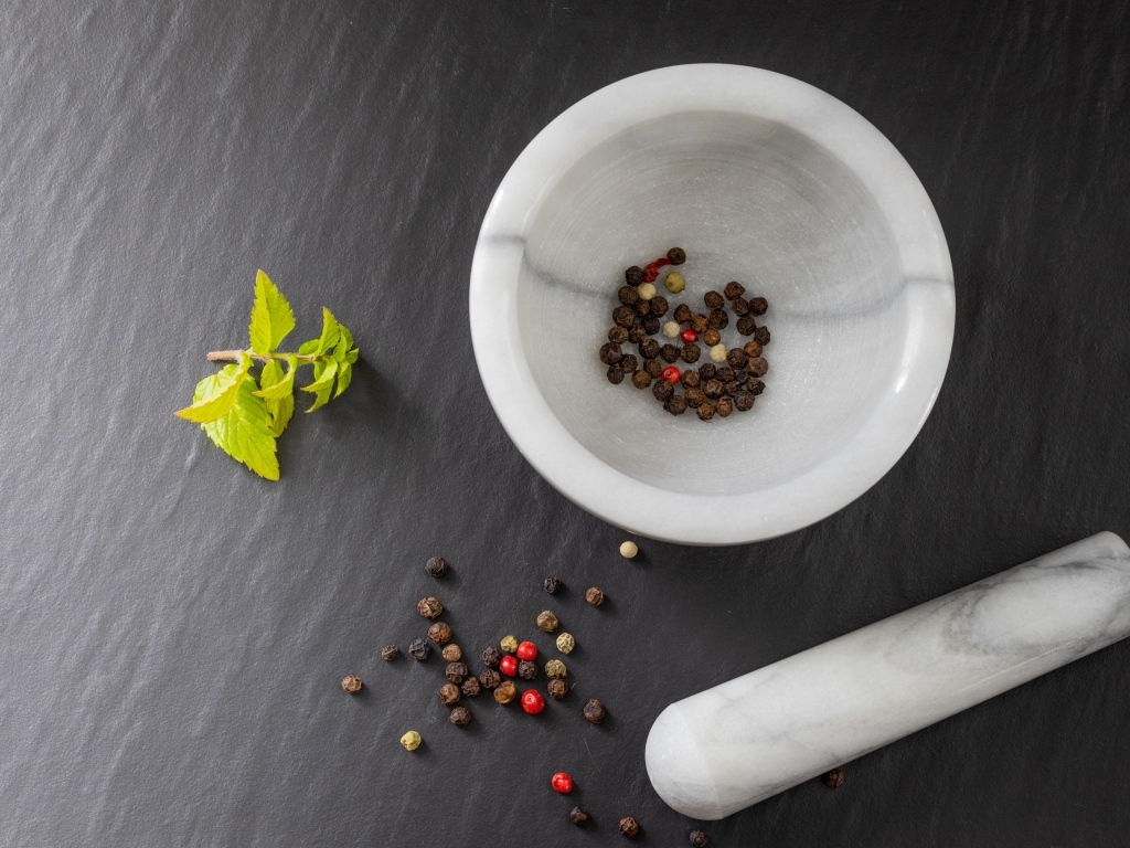 Перец горошком в ступе на сером столе