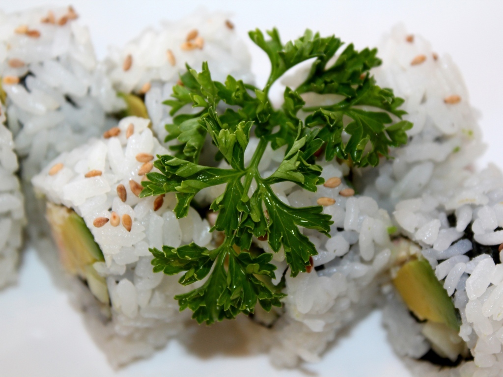 Роллы на тарелке с веточкой петрушки