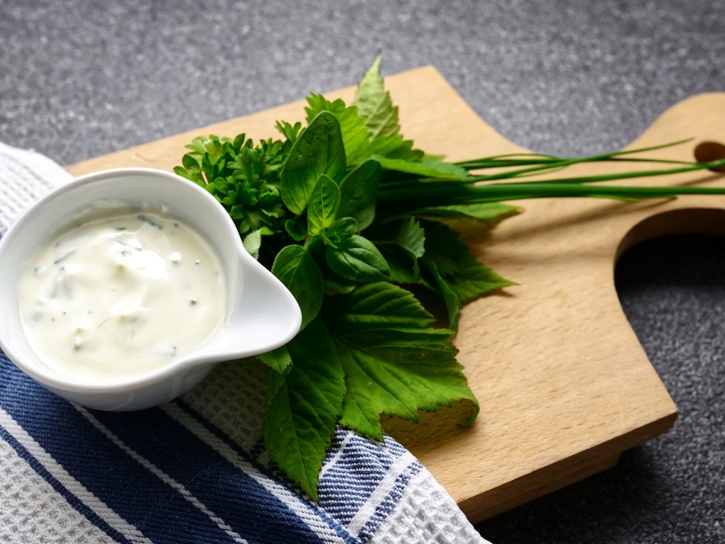 Соус с зеленью на деревянной доске 