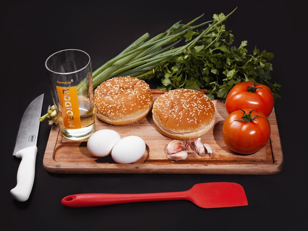 Овощи, яйца, зелень и булочки на черном фоне