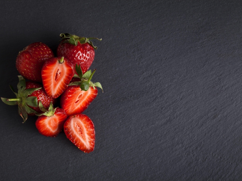Горсть спелой клубники на сером столе