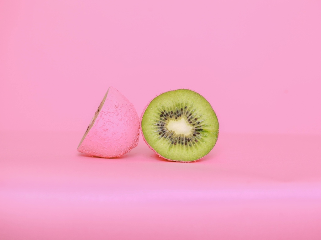 Половинки киви на розовом фоне